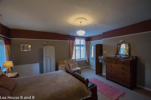 a bedroom with a bed and a dresser and a mirror at Lea House Bed and Breakfast in Ross on Wye