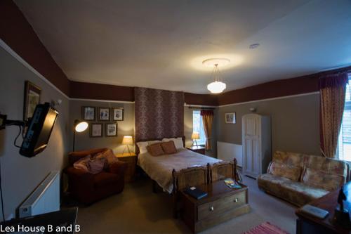 a bedroom with a bed and a living room with a couch at Lea House Bed and Breakfast in Ross on Wye
