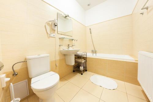 a bathroom with a toilet and a sink and a tub at Villa A. Malka in Poděbrady
