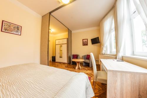 a bedroom with a bed and a desk and a window at Villa A. Malka in Poděbrady