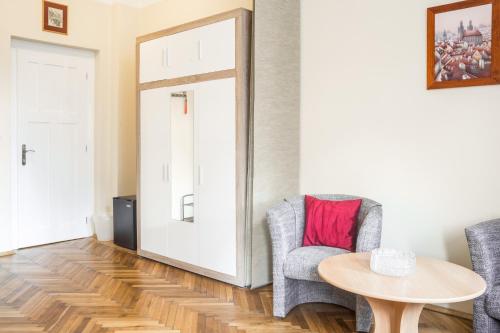 a living room with a table and two chairs and a door at Villa A. Malka in Poděbrady
