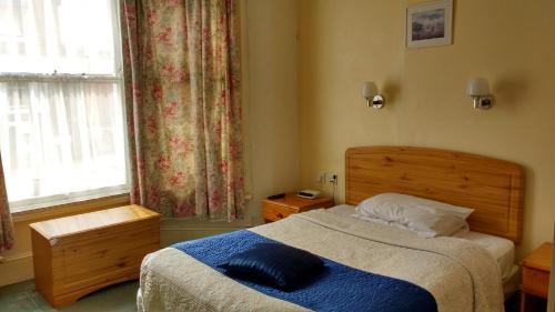 a bedroom with a bed with a blue pillow on it at River Hotel in Oxford