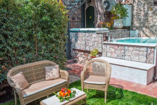 a patio with two chairs and a swimming pool at Private Villa at Villa al Duomo in Taormina
