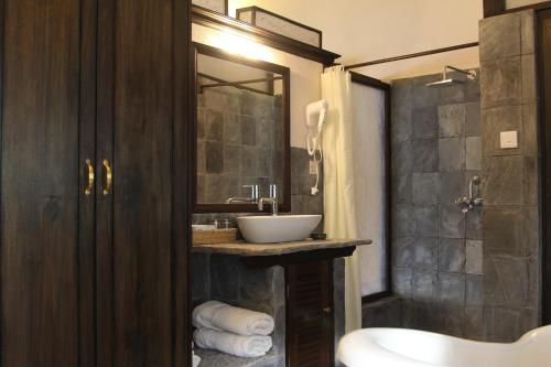 La salle de bains est pourvue d'un lavabo et d'une douche. dans l'établissement The Begnas Lake Resort & Villas, à Pokhara