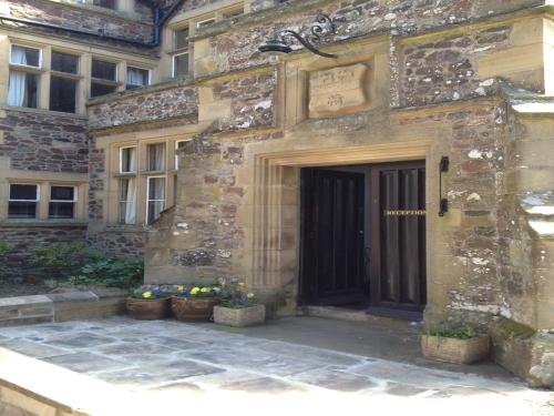 a building with a door and some potted plants at Clennell Hall Country House - Near Rothbury - Northumberland in Alwinton