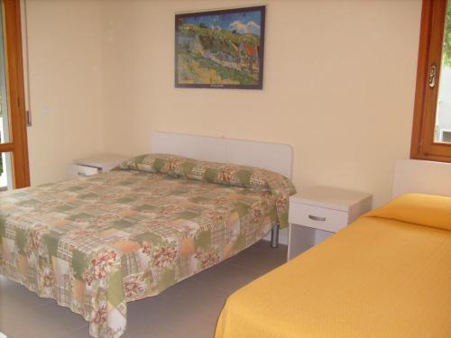 1 dormitorio con 2 camas y una foto en la pared en Condominio Rio Chico, en Lignano Sabbiadoro