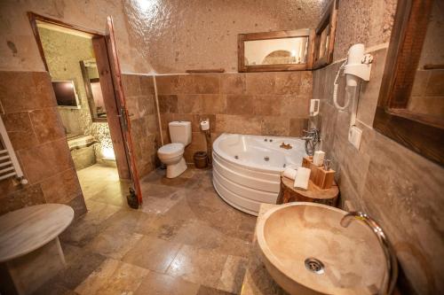 a bathroom with a tub and a toilet and a sink at Wish Cappadocia in Uchisar