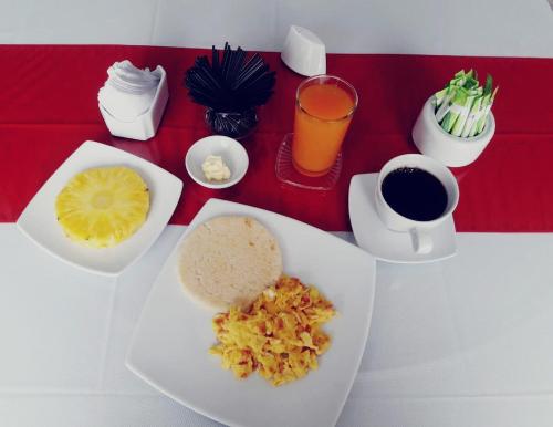 a table with a plate of food and a cup of coffee at Hotel Ingenio Reina Isabel in Cali