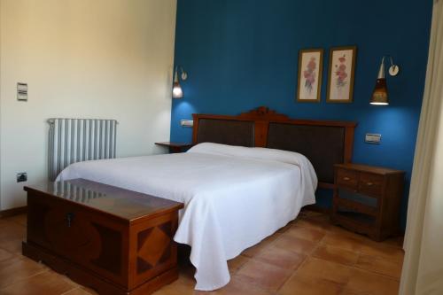 a bedroom with a white bed and blue walls at Hospederia de Loarre in Loarre