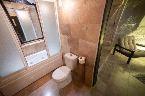 a bathroom with a toilet and a window and a chair at Wish Cappadocia in Uchisar
