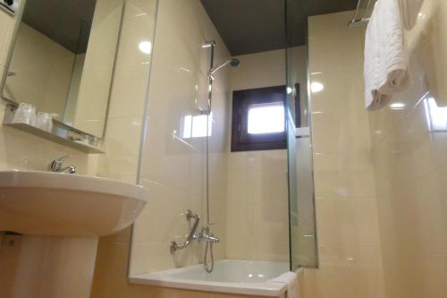 a bathroom with a glass shower and a sink at Hospederia de Loarre in Loarre