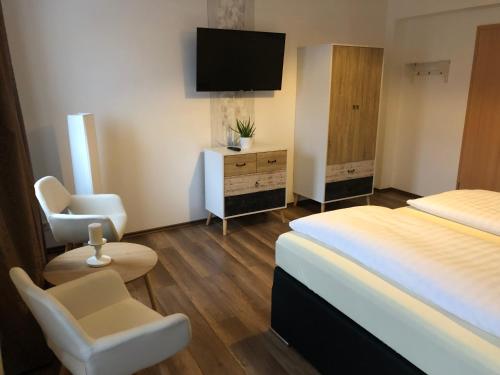 a hotel room with a bed and a television at Hotel garni Zum Rebstock in Naumburg