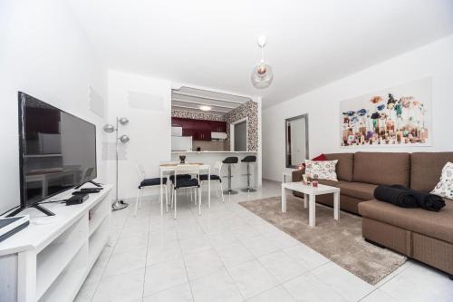 una sala de estar con un sofá y una mesa en Luxury Beach Apartments II, en Playa Honda