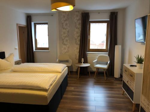 a hotel room with two beds and a table and chairs at Hotel garni Zum Rebstock in Naumburg