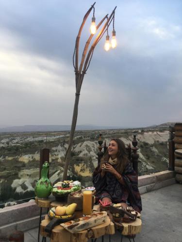 a woman sitting at a table under a street light at Wish Cappadocia in Uchisar