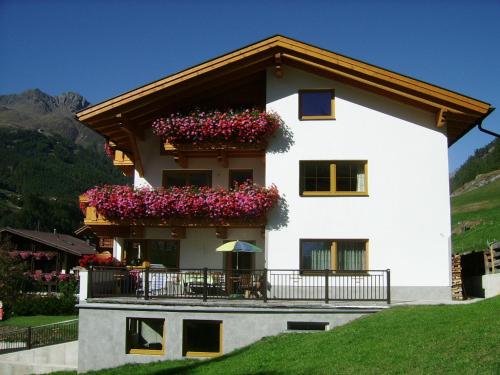 a white house with flowers in a balcony at Haus Birkenheim in Sölden