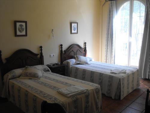 a bedroom with two beds and a window at Hostal Nicol's in Luque