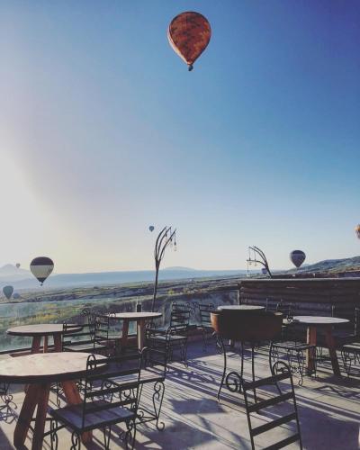a hot air balloon flying over tables and chairs at Wish Cappadocia in Uchisar