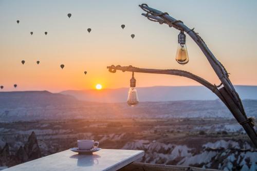 a cup of coffee on a table with the view of the grand canyon at Wish Cappadocia in Uchisar