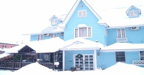 uma casa azul está coberta de neve em Pension Come Relax Tatami-room 12 tatami mats- Vacation STAY 14986 em Minami Uonuma