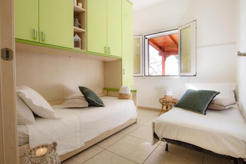 twee bedden in een kamer met groene kasten bij Le Gioie - Dimora Scalelle - Villetta con giardino e veranda vista mare in Torre Vado