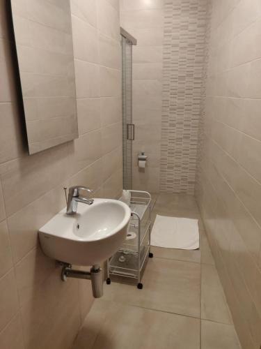 a white bathroom with a sink and a mirror at 189 Chezli Court in Birżebbuġa