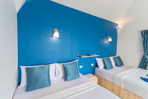 a blue room with two beds with blue walls at Sangthian Beach Resort in Ko Samed