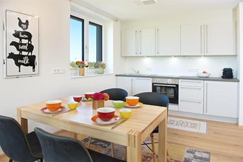 a kitchen and dining room with a wooden table and chairs at Herzberger Ferienwohnungen in Scheidegg
