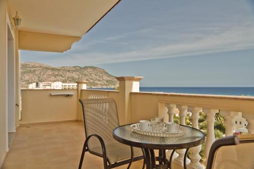 a balcony with a table and chairs and the ocean at Socrates Studios & Apartments in Karpathos Town
