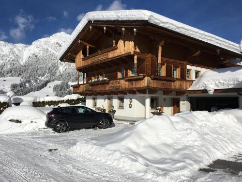 a car parked in front of a house covered in snow at Anna's Appartement in Alpbach