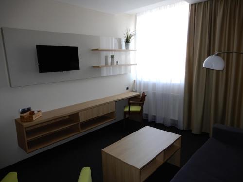 a room with a desk with a tv on a wall at OtavArena in Písek