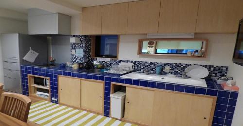 una pequeña cocina con encimera de azulejos azules en Guesthouse Hyakumanben Cross twin room / Vacation STAY 15395, en Kioto