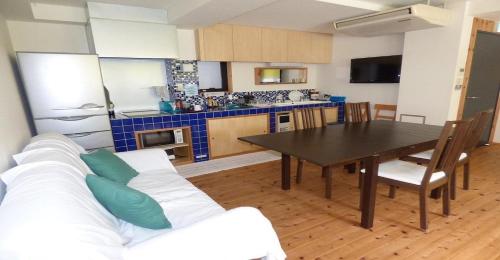 a kitchen with a white couch and a dining room table at Guesthouse Hyakumanben Cross twin room / Vacation STAY 15395 in Kyoto