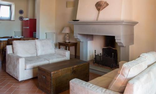a living room with two chairs and a fireplace at Agriturismo Podere La Casa in Palaia