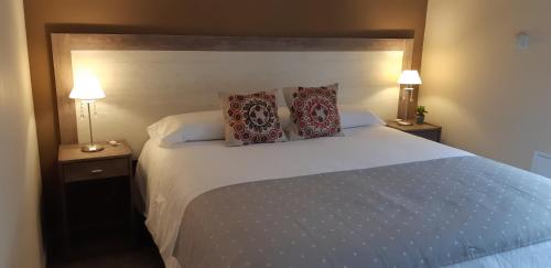 1 dormitorio con 1 cama blanca grande y 2 almohadas en COMPLEJO LOS GUINDOS - USHUAIA FLAT en Ushuaia