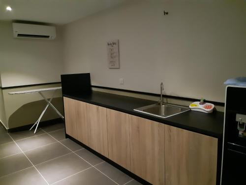 uma cozinha com um lavatório e uma bancada em Monaco Hotel em Cyberjaya