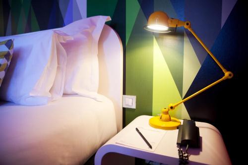a lamp sitting on a table next to a bed at Internacional Design Hotel in Lisbon