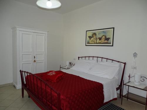 a bedroom with a bed with a red blanket at Residence Terra Dei Santi Country House in Spello