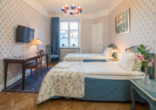 a hotel room with two beds and a desk at Wasa Park Hotel in Stockholm
