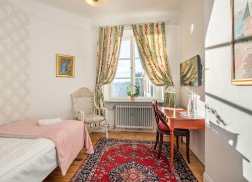 a bedroom with a desk and a bed and a window at Wasa Park Hotel in Stockholm