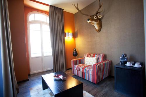 a living room with a chair and a deer head on the wall at Internacional Design Hotel in Lisbon