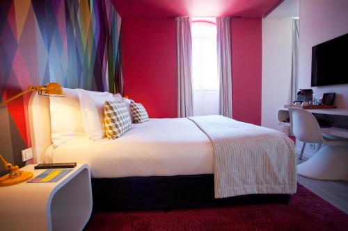 a hotel room with a large bed and a desk at Internacional Design Hotel in Lisbon