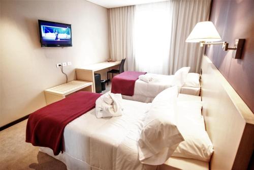a hotel room with two beds and a television at Salto Hotel y Casino in Salto