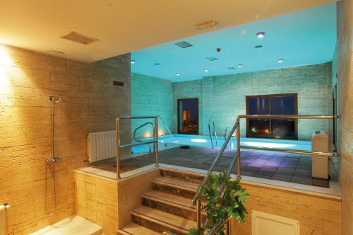 a swimming pool in a room with a tub at Hotel Rural Spa Don Juan de Austria in Jarandilla de la Vera