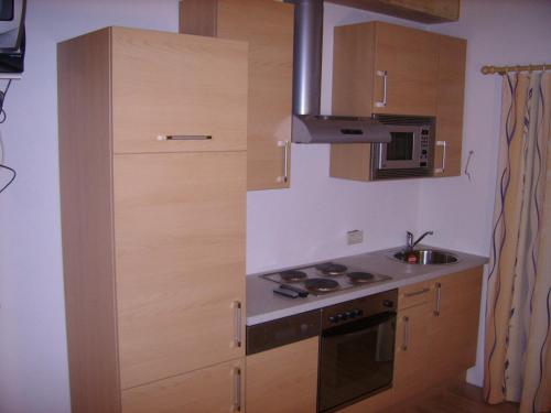 a small kitchen with a stove and a microwave at Haus Birkenheim in Sölden