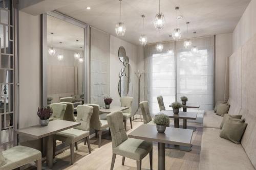 a restaurant with tables and chairs and a mirror at Torretta Palace Hotel in Turanj