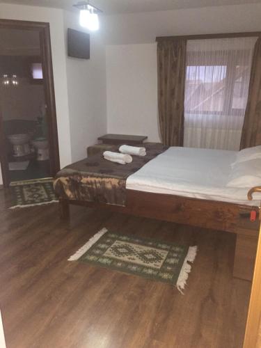 a bedroom with a bed and a window with towels at Casa Ade in Slănic