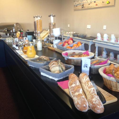 - un buffet composé de pain et de viennoiseries sur une table dans l'établissement Les Jardins d'Hardelot, à Hardelot-Plage