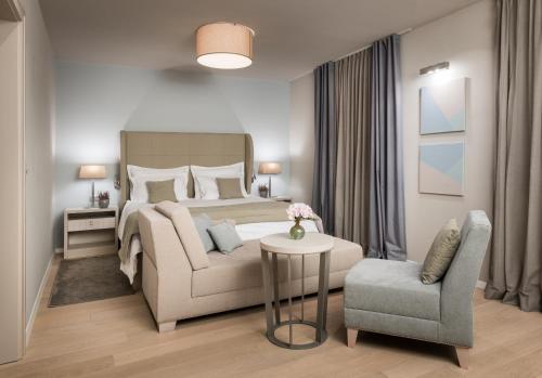 a bedroom with a large bed and a chair at Torretta Palace Hotel in Turanj
