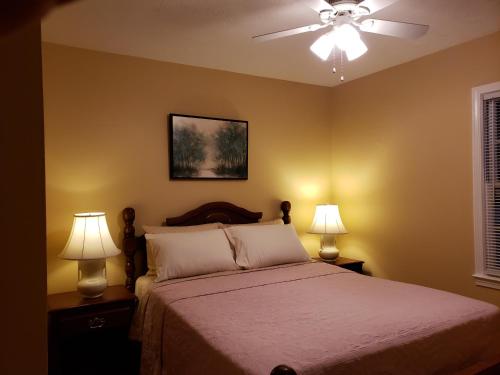 列克星敦的住宿－Cozy and Spacious-4 Bedrooms Townhouse，一间卧室配有一张带两盏灯的床和吊扇。